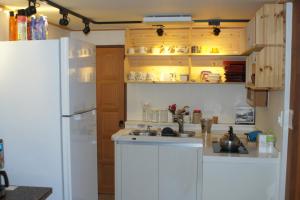 a kitchen with a white refrigerator and a sink at Greem Guesthouse in Jeonju