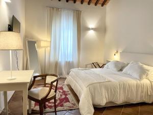a bedroom with a bed and a table and a chair at Agriturismo Antica Corte - Ortensie in Montepulciano
