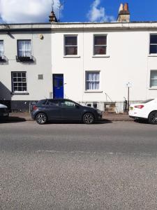 um carro preto estacionado em frente a um edifício branco em Pulteney Road Apartment em Bath
