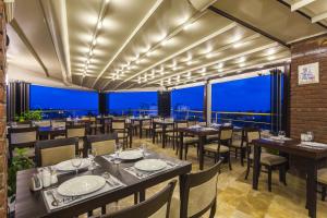 un restaurante con mesas y sillas y vistas en Ayhan Hotel, en Antalya