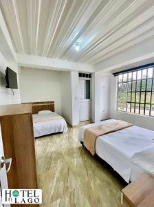 1 dormitorio con 2 camas y TV. en Hotel El Lago en Mocoa
