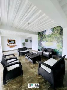 ein Wohnzimmer mit schwarzen Stühlen und einem großen Gemälde in der Unterkunft Hotel El Lago in Mocoa