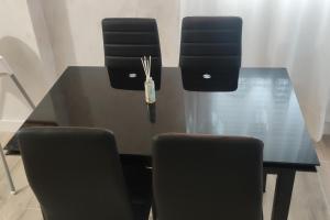 a black dining room table with two chairs and a bottle at Apartamento Centro A in San Sebastián de los Reyes