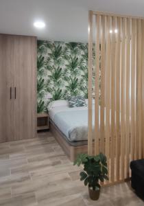 1 dormitorio con 1 cama con papel pintado tropical en Apartamento Centro A, en San Sebastián de los Reyes