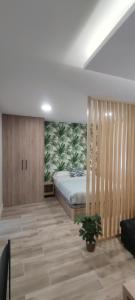 ein Schlafzimmer mit einem Bett und einer Pflanze in der Unterkunft Apartamento Centro A in San Sebastián de los Reyes
