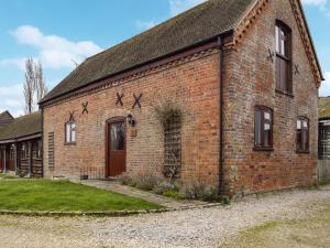 an old red brick building with a door at The Old Stable - Meadowbrook Farm in Thame
