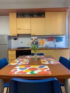 Una cocina con una mesa con un jarrón de flores encima. en Metro Suite Milano, en Milán