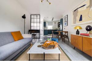 ein Wohnzimmer mit einem Sofa und einem Tisch in der Unterkunft Contemporary central flat in Clerkenwell Green in London