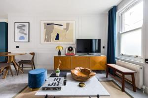ein Wohnzimmer mit einem TV und einem Tisch in der Unterkunft Contemporary central flat in Clerkenwell Green in London