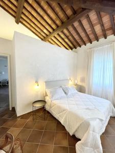 una camera da letto con un grande letto bianco e un tavolo di Agriturismo Antica Corte - Rose a Montepulciano