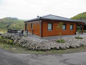 Cabaña con pared de piedra junto a una casa en Ferienhaus Merlin, en Rieden