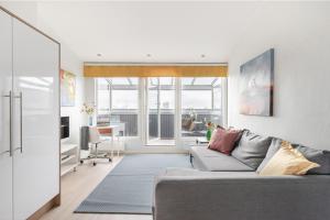 a living room with a gray couch and a table at Citykoti Downtown Studios in Helsinki