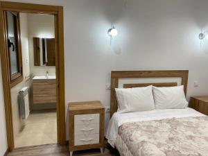 ein Schlafzimmer mit einem Bett und ein Badezimmer mit einem Spiegel in der Unterkunft Fraga de Pitões in Pitões das Júnias
