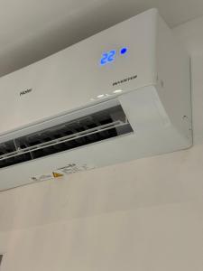 a white microwave oven sitting on top of a wall at Stylish Balinimo Guest room - King Bed, Free Netflix, Prime & Wi-Fi Near Bukit Mertajam in Kubang Semang