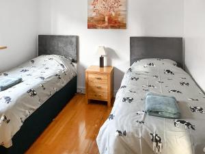ein Schlafzimmer mit einem Bett und einem Nachttisch mit einem Bett von 6 x 6 cm in der Unterkunft Cedar Lodge in Old Buckenham