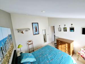 sypialnia z niebieskim łóżkiem i balkonem w obiekcie Gîte Le Magourin w mieście Belz