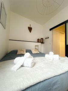 a bedroom with a bed with white towels on it at Voyage au Canal - Parking Clim Netflix Amazon in Montauban +10 photos