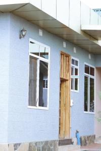 une maison bleue avec une porte et des fenêtres dans l'établissement Briston Hotel - Mugumu, à Mugumu