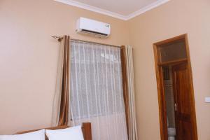 - une chambre avec une fenêtre et la climatisation au plafond dans l'établissement Briston Hotel - Mugumu, à Mugumu