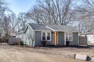 a small gray house with a yellow door at 2 Mi to UA Central Fayetteville Home with Patios in Fayetteville
