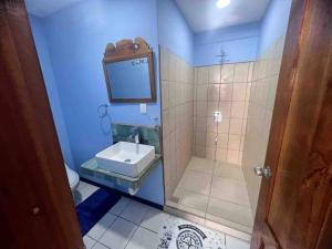 La salle de bains bleue est pourvue d'un lavabo et d'une douche. dans l'établissement Puntarenas, Apartamento Mateo, à Puntarenas