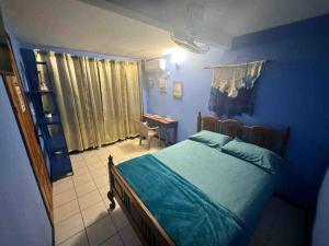 a blue bedroom with a bed and a desk at Puntarenas, Apartamento Mateo in Puntarenas