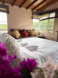 a bedroom with a white bed with purple flowers at Casa Pandora A 5 minutos aeropuerto Medellin in Santa Elena
