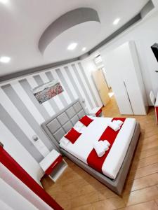 um quarto com uma cama grande com lençóis vermelhos e brancos em Affittacamere ELVI em La Spezia