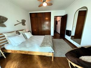 una camera da letto con un letto grande e un divano di Caparica Central Apartment by HOST-POINT a Costa da Caparica