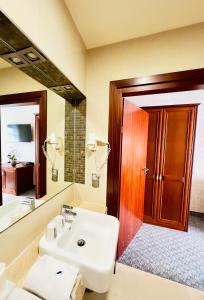 La salle de bains est pourvue d'un lavabo et d'un miroir. dans l'établissement Hotel&Spa Stary Dziwnów basen swimming pool, à Dziwnów