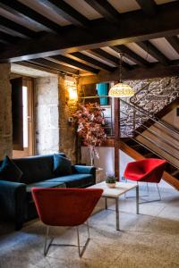 a living room with a blue couch and red chairs at Hotel Alda Bonaval in Santiago de Compostela