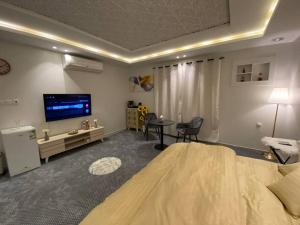 a living room with a large bed and a tv at غرفه مستقله بدورة مياه حي طويق in Riyadh
