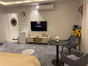 a room with a bed and a table and a tv at غرفه مستقله بدورة مياه حي طويق in Riyadh