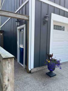 a building with a door and a vase with flowers at Blue door loft upper apartment in Thorold