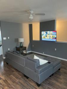 a living room with a couch and a flat screen tv at Blue door loft upper apartment in Thorold