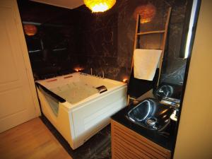 a bathroom with a sink and a bath tub at Love room avec jaccuzzi in Mormant