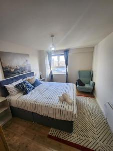 a bedroom with a large bed and a chair at City View Salford in Manchester