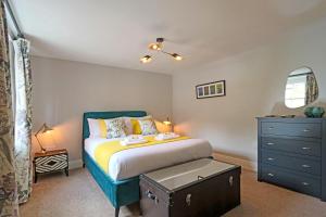 una camera con letto con testiera blu e cassettiera di Beautiful Character Cottage a Milford