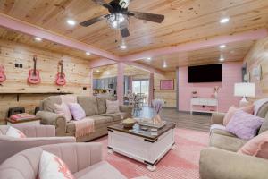 a living room filled with furniture and a flat screen tv at Pink Pines AvantStay Luxury Aesthetic Dream Home Indoor Pool Hot Tub in Pigeon Forge