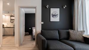a living room with a couch and a black wall at VacationClub - Apartamenty Zakopiańskie Apartament 16 in Zakopane