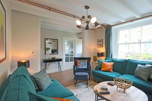 a living room with a blue couch and a table at Beautiful Character Cottage in Milford