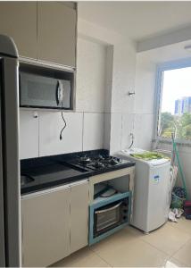 a white kitchen with a stove and a refrigerator at Não está disponível para locação in Ilhéus