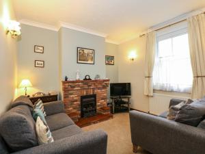 a living room with two couches and a fireplace at 5 Melinda Cottages in West Runton