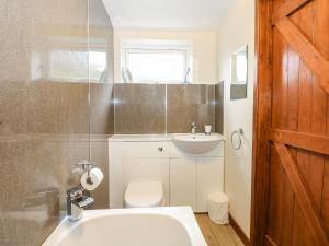 a bathroom with a white sink and a toilet at 5 Melinda Cottages in West Runton +23 photos
