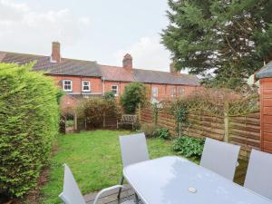 a table and chairs in the backyard of a house at 5 Melinda Cottages in West Runton