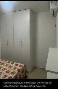 a bedroom with a bed and white cabinets at Não está disponível para locação in Ilhéus
