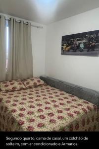 a bedroom with a bed with a floral bedspread at Não está disponível para locação in Ilhéus