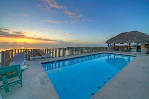 - une piscine avec vue sur l'océan au coucher du soleil dans l'établissement Big Trout by AvantStay Coastal Group Getaway, à Île Padre