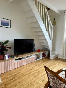 een woonkamer met een televisie en een trap bij Le 30 Rennais - T4 en plein centre ville in Rennes
