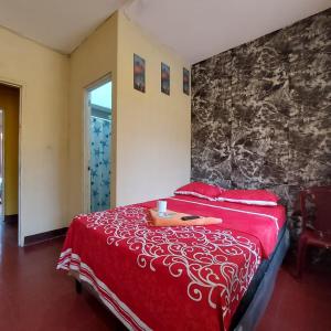 1 dormitorio con cama roja y pared de piedra en Hotel Villas de San Juan, Guatemala, en Guatemala